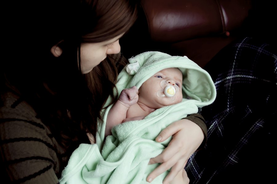 A parent cuddling a baby wrapped in a soft hooded towel after bath time