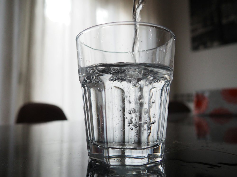 Fresh water being poured into a clear glass